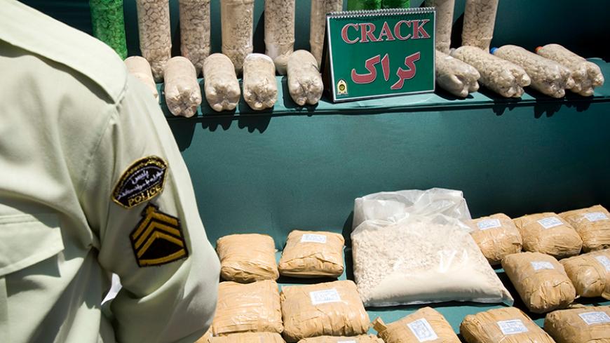 An Iranian anti-narcotics policeman stands guard beside a display of confiscated drugs during a ceremony concluding anti-narcotics manoeuvres in Zahedan, 1,605 kilometers (1,003 miles) southeast of Tehran May 20, 2009.  The head of the U.N. crime agency praised Iran during a visit on Wednesday for curbing the flow of smuggled heroin from Afghanistan and helping keep the drug off Western streets.  Picture taken May 20, 2009. REUTERS/Caren Firouz (IRAN CRIME LAW POLITICS SOCIETY) - RTXKL1B