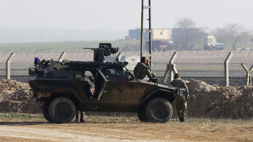 Turkish soldiers monitor the border line as they stand guard near the Akcakale border crossing in Sanliurfa province, southeastern Turkey, where Islamic State militants control the Syrian side of the gate, January 29, 2015. An audio message purportedly from a Japanese journalist being held by Islamic State militants said a Jordanian air force pilot also captured by the group would be killed unless an Iraqi female prisoner in Jordan was released by sunset on Thursday. The message appeared to postpone a previ
