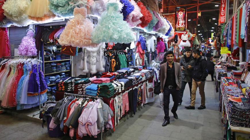 People walk past shops at a bazaar in the central Anatolian city of Kayseri February 13, 2015. President Tayyip Erdogan's tirades against the central bank may be stoking turmoil in Turkish financial markets, but they are winning praise from a class of industrialists who have thrived over the past decade and see him as a pillar of their success. Picture taken February 13, 2015. REUTERS/Umit Bektas (TURKEY - Tags: BUSINESS POLITICS) - RTR4RF73