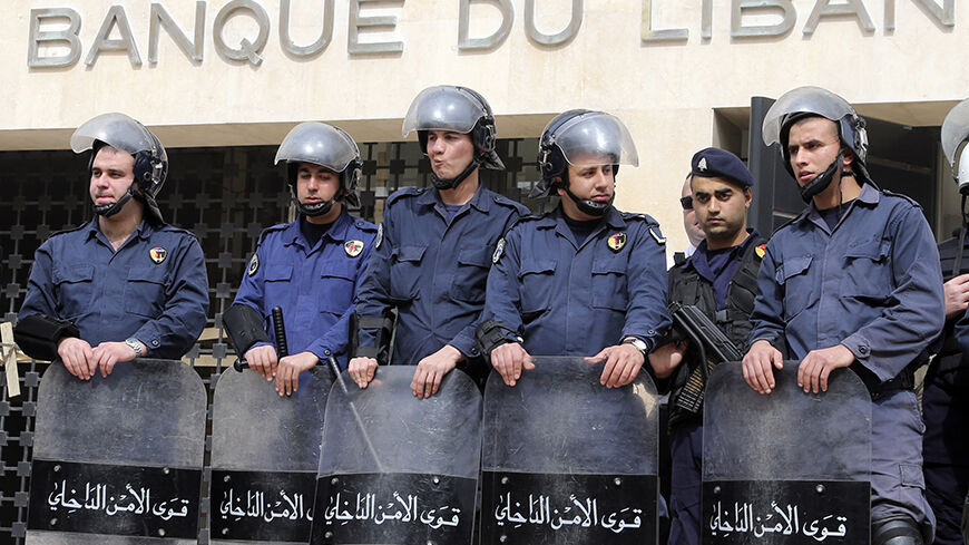 Lebanese riot police stand guard at the Lebanese Central Bank in Beirut February 25, 2013. An open-ended strike by teachers and civil servants entered its second week today for the government to approve the wage hike proposal. REUTERS/Mohamed Azakir (LEBANON - Tags: POLITICS CIVIL UNREST) - RTR3E9U4