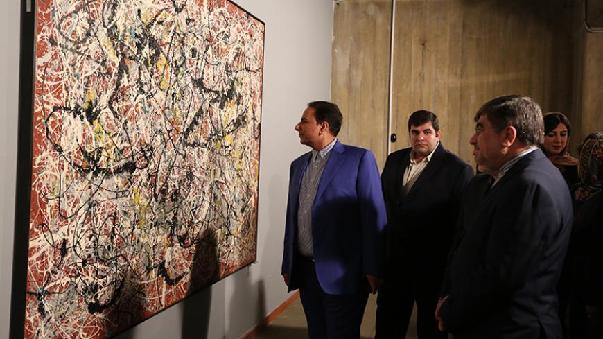 TO GO WITH AFP STORY BY ARTHUR MACMILLAN
Iranian Culture Minister Ali Jannati (R) looks at US artist Jackson Pollock's "Mural on Indian Red Ground" (1950) during the opening ceremony of an exhibition of modern art at Tehran's Museum of Contemporary Art (TMOCA) in the capital, on November 20, 2015. Some of the world's most expensive and rarely seen modern art, including works by the Americans Jackson Pollock and Andy Warhol, which are part of a collection bought in the 1970s by dealers acting for Farah, the