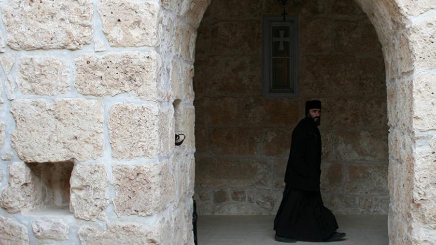 A Syriac Christian monk walks to attend a service at the ancient monastery of Mor Gabriel, 15 km (9 miles) from the town of Midyat, in Mardin province of southeast Turkey January 13, 2009. Tucked amid rugged hills where mosques and minarets are silhouetted in the distance, the fifth century Mor Gabriel monastery stands out as a relic of another era when hundreds of thousands of Syriac Christians lived and worshipped in Turkey. But a land dispute between Mor Gabriel and neighbouring villages is threatening t