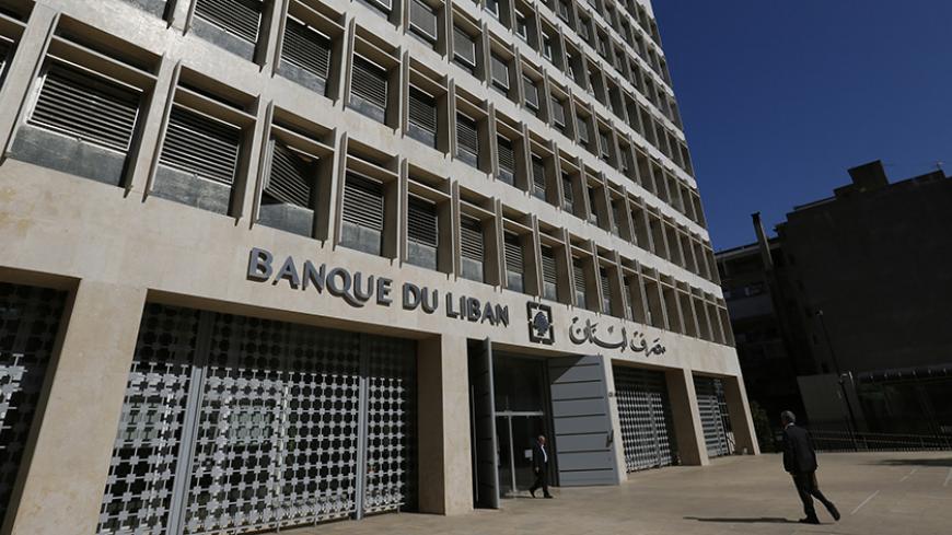 People walk outside Lebanon's Central Bank in Beirut November 6, 2014. Lebanon's central bank prides itself on being one of the few institutions to survive the country's 15-year civil war intact. Now, as a new war rages in neighbouring Syria, that role is more important than ever. Picture taken November 6, 2014. REUTERS/Jamal Saidi  (LEBANON - Tags: BUSINESS SOCIETY) - RTR4EQW4