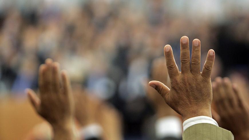 Algerian lawmakers raise their hands to approve the limited constitutional change in Algiers November 12, 2008. Algerian lawmakers on Wednesday scrapped a rule limiting presidents to two terms, a move seen by opposition parties in the OPEC member state as aimed at letting head of state Abdelaziz Bouteflika stay in office for life.   REUTERS/Louafi Larbi (ALGERIA) - RTXAIO1