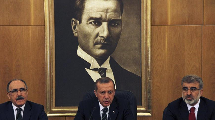 Turkey's Prime Minister Tayyip Erdogan, flanked by his deputy Besir Atalay (L) and Energy Minister Taner Yildiz (R), speaks during a news conference at Ataturk International airport in Istanbul April 4, 2014. Turkish Prime Minister Tayyip Erdogan called on Friday for the central bank to cut interest rates, sending the lira lower, and said he favoured keeping a three-term limit for ruling party deputies, suggesting he may run in August presidential polls. In his first public comments since a victory speech a