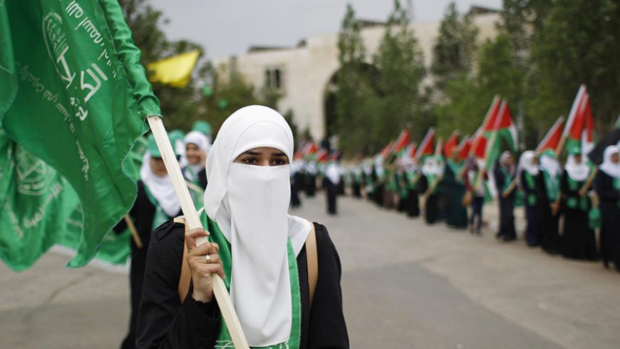 A Palestinian student supporting the Hamas movement holds a Hamas flag as she takes part in an election campaign for the student council at the Birzeit University in the West Bank city of Ramallah  May 6, 2014. 
The political parties are competing for the student council's 51 seats in an election that will take place on Wednesday.
  REUTERS/Mohamad Torokman (WEST BANK - Tags: POLITICS EDUCATION) - RTR3O04M
