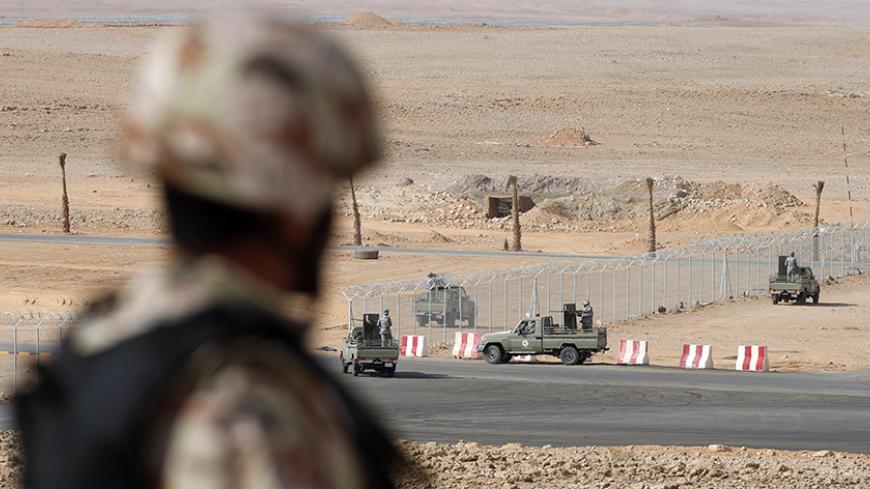 A member of the Saudi security forces stands guard as other demonstrate their skills during a military exercise in Arar, near Saudi Arabia's northern border with Iraq March 18, 2015. REUTERS/Faisal AlNasser (SAUDI ARABIA - Tags: MILITARY POLITICS) - RTR4TWNJ