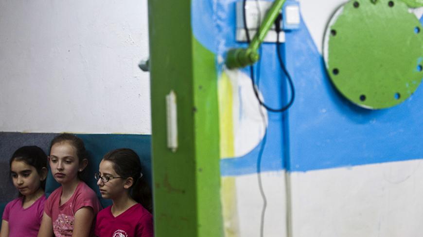 Israeli elementary school students stand near the entrance to a bomb shelter during a nationwide emergency drill simulating a rocket attack, in Jerusalem June 2, 2015. Israel launched a five-day annual home front defence exercise on Sunday, preparing soldiers and civilians for missile attacks. REUTERS/Ronen Zvulun - RTR4YGUV