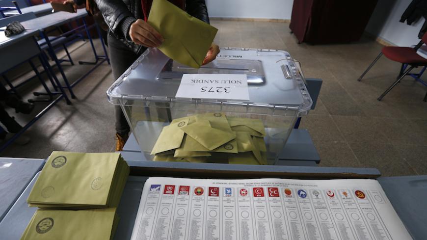 A woman casts her ballot at a polling station in Istanbul, Turkey November 1, 2015. Turks began voting on Sunday amid worsening security and economic worries in a snap parliamentary election that could profoundly impact the divided country's trajectory and that of President Tayyip Erdogan. The parliamentary poll is the second in five months, after the ruling AK Party founded by Erdogan failed to retain its single-party majority in June.  REUTERS/Murad Sezer - RTX1U7P0
