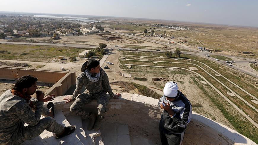 Shi'ite fighters sit on the top of Spiral Minaret of the Great Mosque in Samarra, February 3, 2016. Picture taken February 3, 2016. REUTERS/Ahmed Saad - RTX25EVC