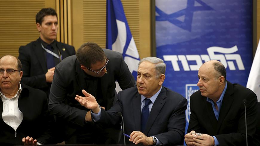 Israel's Prime Minister Benjamin Netanyahu (C) chats with members of his party during a meeting of his Likud party meeting in the Israeli parliament in Jerusalem February 8, 2016. A bill that opponents say targets Israeli human rights groups critical of Israel's policies towards the Palestinians was set to win initial approval in parliament on Monday with the support of the country's right-wing. It is widely expected to receive preliminary approval in the Knesset late on Monday. REUTERS/Ronen Zvulun - RTX