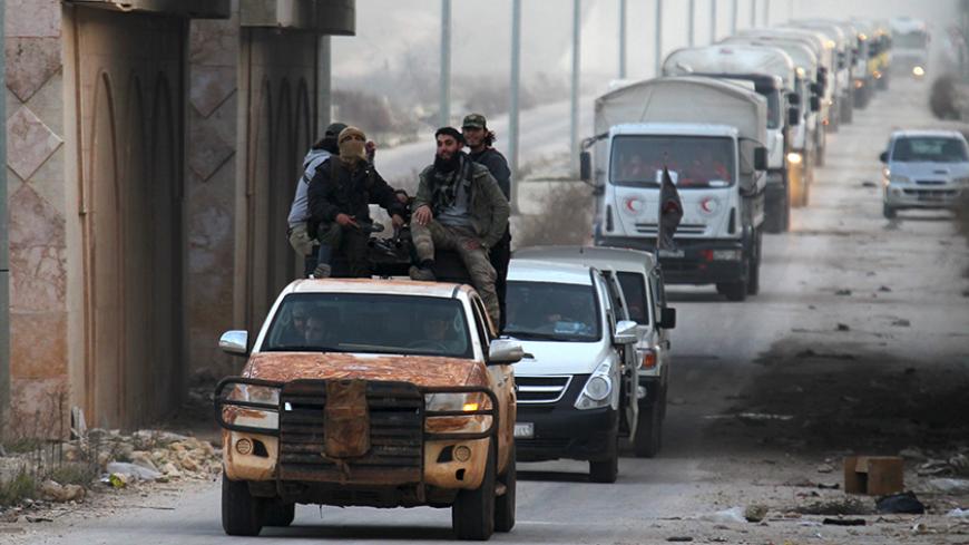 Rebel fighters escort a Syrian Arab Red Crescent aid convoy heading towards the villages of al-Foua and Kefraya in Idlib province, Syria February 17, 2016. REUTERS/Ammar Abdullah       TPX IMAGES OF THE DAY      - RTX27EF4