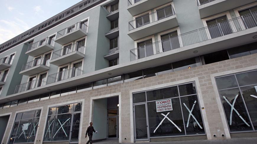 A man walks near a "for rent" sign posted on a newly-built residential building in Jaffa, just south of central Tel Aviv, January 4, 2010. Almost 500 Arab families are struggling to keep a toehold in Ajami, the Arab section of Jaffa that is rapidly becoming an artsy alternative to the brash modernity of Israel's metropolis Tel Aviv next door. Picture taken January 4, 2010. To match feature ISRAEL-ARABS/PROPERTY REUTERS/Gil Cohen Magen (ISRAEL - Tags: POLITICS BUSINESS SOCIETY) - RTR28TF5