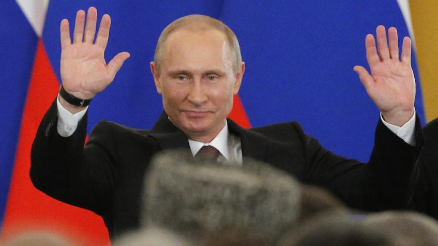Russian President Vladimir Putin waves to the Federal Assembly after a signing ceremony at the Kremlin in Moscow March 18, 2014. Putin and two Crimean leaders signed a treaty on Tuesday on making the Ukrainian Black Sea peninsula a part of Russia. The signing in the Kremlin came two days after Crimeans voted overwhelmingly to secede from Ukraine and join Russia in a referendum condemned by the Ukrainian government, the United States and the European Union as illegitimate. REUTERS/Maxim Shemetov (RUSSIA - Ta