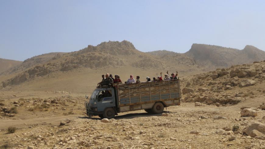 Displaced people from the Yazidi religious minority, fleeing violence from forces loyal to the Islamic State in Sinjar town, ride on a truck as they are evacuated from Mount Sinjar in northern Iraq with the help of members of the Kurdish People's Protection Units (YPG), as they make their way towards Newrooz camp in Syria's al-Hasakah province, August 13, 2014. A U.S. mission to evacuate Yazidis trapped on Mount Sinjar by Sunni militant fighters is far less likely after a U.S. assessment team sent there on 