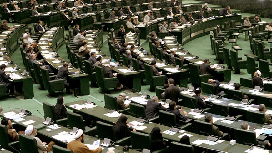 Iranian MP's hold session in Iran's new parliament building in Tehran November 16, 2004. Iranian hardliners are angered over a deal Tehran has agreed with the European Union to suspend all activities related to its enrichment programme in a bid to allay international fears about its nuclear ambitions. REUTERS/Morteza Nikoubazl  CJF/THI - RTRFVC4
