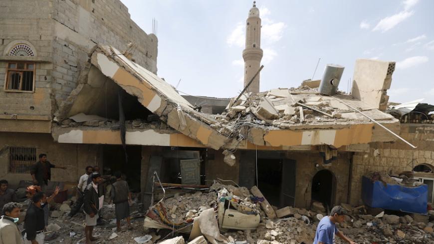 People walk at the site of a Saudi-led air strike in Yemen's capital Sanaa September 21, 2015. More than 4,500 Yemeni have been killed since the Saudi-led alliance began military operations in March, in what they said was an attempt to stop the Iranian-allied Houthi group from expanding in Yemen and to restore President Abd-Rabbu Mansour Hadi, who had been pushed into exile in Saudi Arabia.   REUTERS/Khaled Abdullah - RTS253B