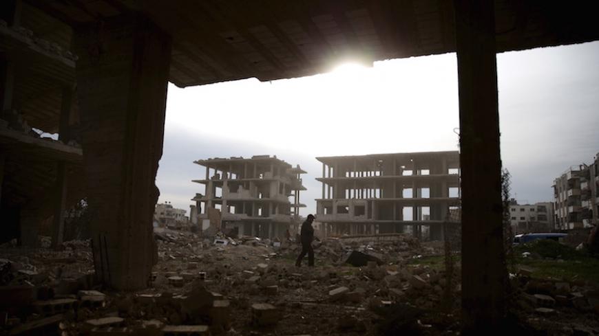 A man walks on the rubble of damaged buildings in the rebel-controlled area of Jobar, a suburb of Damascus, Syria March 2, 2016. REUTERS/Bassam Khabieh - RTS8ZZ9