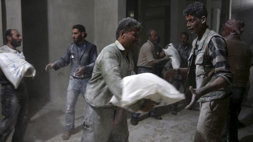 Men store bags of flour unloaded from a Red Crescent aid convoy in the rebel held besieged town of Jesreen, in the eastern Damascus suburb of Ghouta, Syria March 7, 2016. REUTERS/Bassam Khabieh      TPX IMAGES OF THE DAY      - RTS9Q41