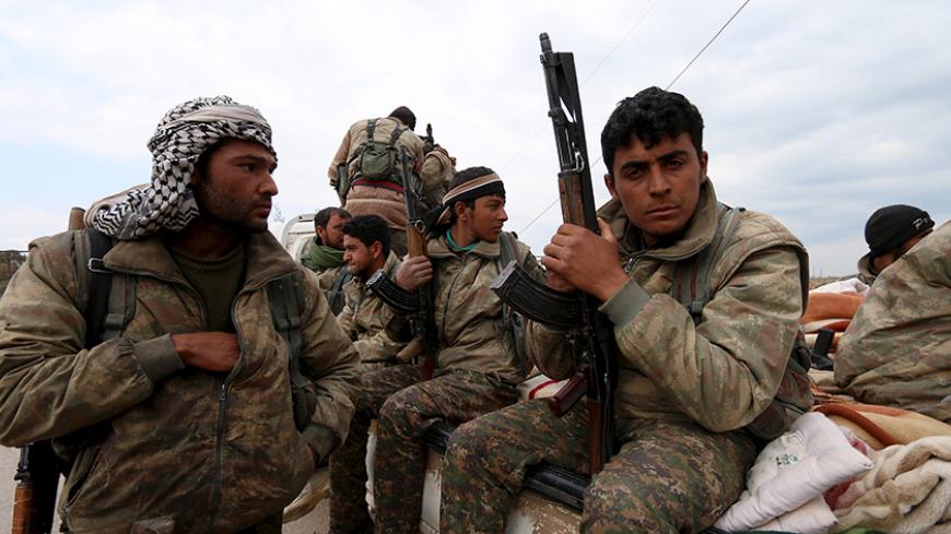 Kurdish People's Protection Units (YPG) fighters carry their weapons while riding on the back of a pick-up truck in Qamishli, Syria, March 11, 2016. REUTERS/Rodi Said - RTSADJ7