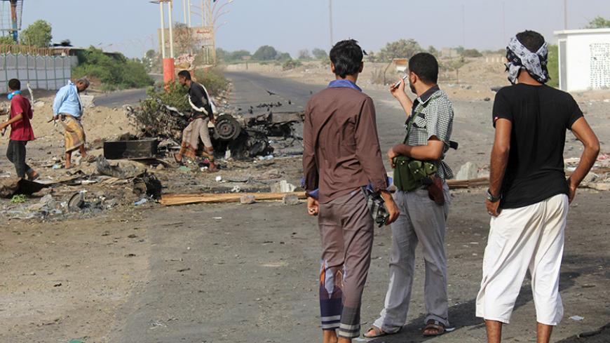 People look at the site of a suicide bombing in Yemen's southern port city of Aden March 26, 2016. REUTERS/Fawaz Salman - RTSCBIP