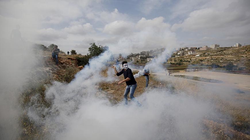 A Palestinian protester returns a tear gas canister fired by Israeli troops during clashes near Israel's Ofer Prison near the West Bank city of Ramallah May 22, 2015. REUTERS/Mohamad Torokman
TPX IMAGES OF THE DAY - RTX1E56H