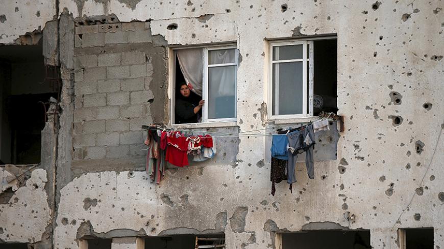 A Palestinian woman looks out her apartment in a residential buildings, that witnesses said was heavily damaged by Israeli shelling during a 50-day war last summer, in Beit Lahiya town in the northern Gaza Strip May 25, 2015. REUTERS/Suhaib Salem
TPX IMAGES OF THE DAY - RTX1EI6U