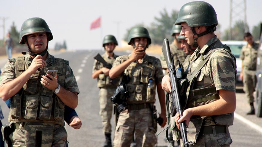 Turkish soldiers stand guard as a funeral convoy, carrying coffins of drowned Syrian migrants including the three-year old boy Aylan Kurdi, drives to the Turkish-Syrian border in Suruc, bordering with the northern Syrian town of Kobani, Turkey, September 4, 2015. Two Syrian toddlers who drowned with their mother as they were trying to reach Greece were laid to rest in the Syrian town of Kobani on Friday, a Reuters witness said. A photograph of the body of one of the toddlers, 3-year-old Aylan Kurdi, washed 