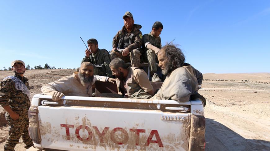 Three men that Democratic Forces of Syria fighters claimed were Islamic State fighters sit on a pick-up truck while being held as prisoners, near al-Shadadi town, Hasaka countryside, Syria, February 18, 2016. REUTERS/Rodi Said - RTX27LV4