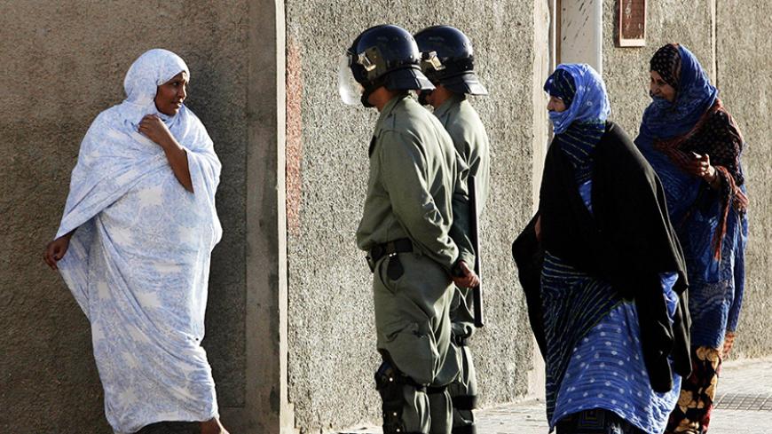 Women walk by Moroccan police on the streets of El Aaiun, western Sahara, November 6, 2005. Moroccan police were on alert fearing Saharawi demonstrations calling for self-determination to the Saharawi people on the 30th anniversary of the Green March. On November 6, 1975 the so-called Green March into Western Sahara began when 300,000 Moroccans crossed into Western Sahara following the orders of King Hassan II of Morocco to force Spain to hand over the territory. As a result, Spain abandoned Western Sahara 