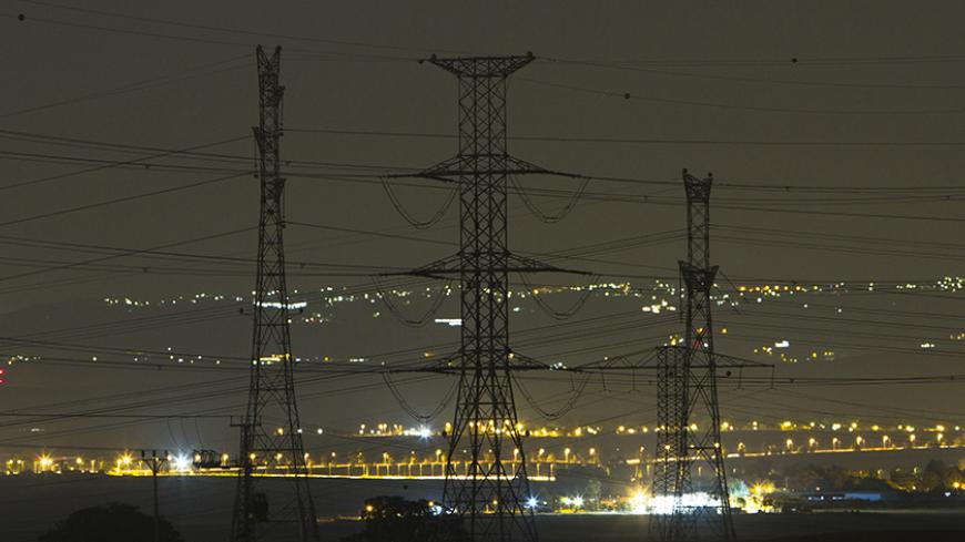 Electricity pylons and power transmission lines are seen at night near Kibbutz Negba in southern Israel May 17, 2012. Israel Electric Corp (IEC), which is responsible for nearly every aspect of electricity from running power plants to connecting households, simply cannot keep up with growing demand.The state-owned utility just lost natural gas supplies from neighbouring Egypt and fuel costs are soaring. Reserves are low and capacity insufficient and the government, under pressure from massive cost-of-living