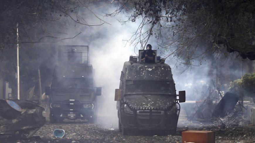 Riot policemen travel in their vehicles as they release tear gas during clashes with protesters along a road leading to the U.S. embassy, near Tahrir Square in Cairo November 28, 2012. Hundreds of demonstrators were in Cairo's Tahrir Square for a sixth day on Wednesday to demand that President Mohamed Mursi rescind a decree they say gives him dictatorial powers, and two of Egypt's top courts stopped work in protest. REUTERS/Amr Abdallah Dalsh  (EGYPT - Tags: POLITICS CIVIL UNREST) - RTR3AZL8