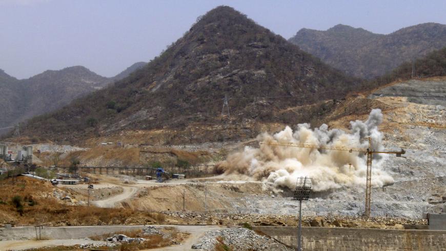 A cloud of dust rises from a dynamite blast, as part of construction work, at Ethiopia's Grand Renaissance Dam during a media tour along the river Nile in Benishangul Gumuz Region, Guba Woreda, in Ethiopia March 31, 2015. According to a government official, the dam has hit the 41 percent completion mark. Picture taken March 31, 2015. REUTER/Tiksa Negeri  - RTR4VQ69