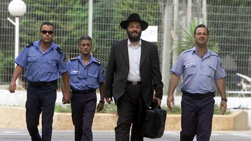 Former Israeli government kingmaker and ex-leader of the ultra-orthodox
Shas Party Aryeh Deri is escorted by policemen as he walks out of
prison July 15, 2002 after serving two years of a three-years sentence
for corruption. Deri, released a year early for "good behaviour", said
he would devote himself to social work and that he would seek a
retrial. REUTERS/Nir Elias
NIR/RS - RTR7NTA