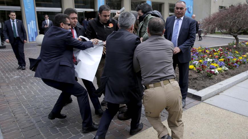 Turkish security personnel struggle to take a sign away from protesters in front of the Brookings Institute before the arrival of Turkish President Recep Tayyip Erdogan in Washington, March 31, 2016. REUTERS/Joshua Roberts - RTSD14K