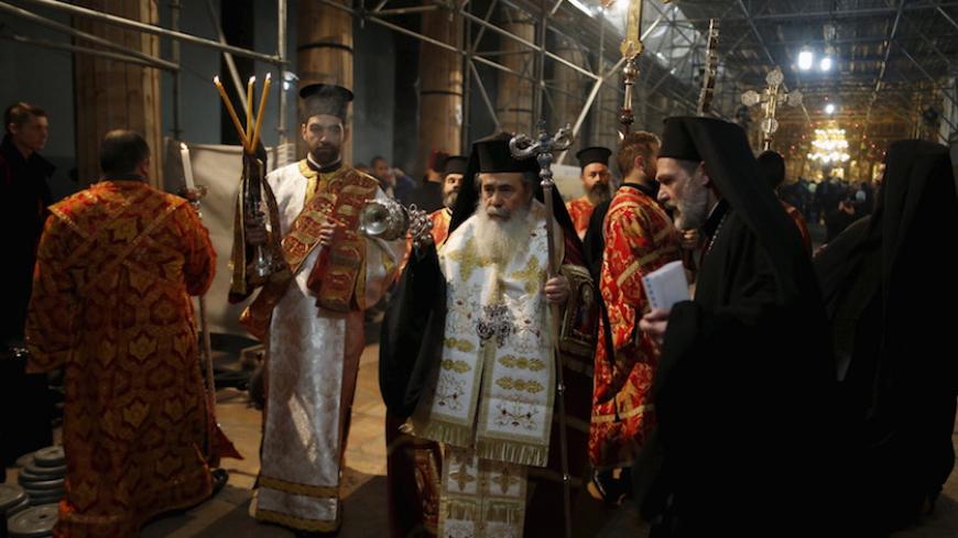 The Greek Orthodox Patriarch of Jerusalem Theophilos III (C) attends a Christmas service according to the Eastern Orthodox calendar, in the church of Nativity in the West Bank city of Bethlehem January 6, 2016. REUTERS/Ammar Awad - RTX219EO