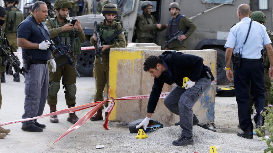 Israeli forces inspect the scene where a Palestinian, whom the Israeli military said attacked Israeli soldiers with an axe, was shot dead at the entrance of Arroub refugee camp, north of the West Bank city of Hebron April 14, 2016. REUTERS/Mussa Qawasma TPX IMAGES OF THE DAY - RTX29Y9E