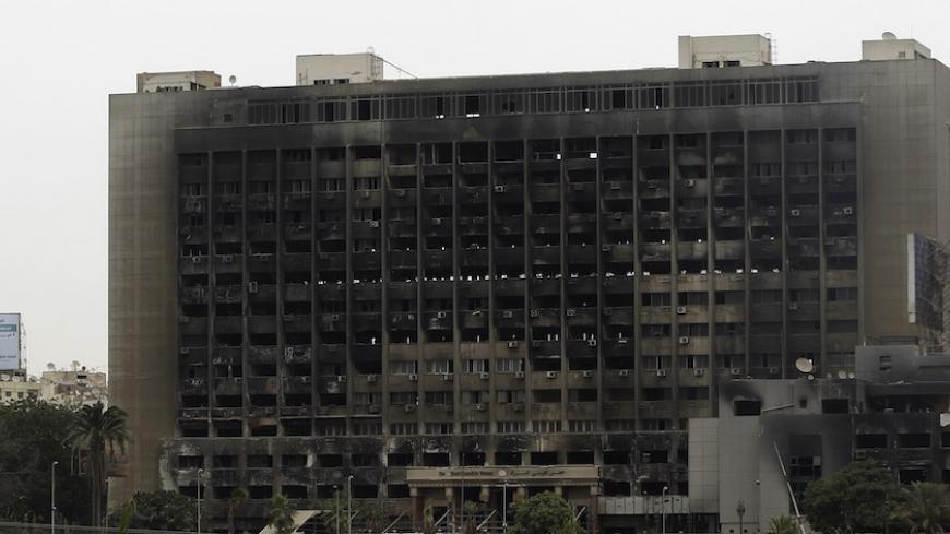 The burned headquarters of former President Hosni Mubarak's National Democratic Party (NDP) is seen between campaign election billboards of presidential candidates, former Prime Minister Ahmed Shafiq (L), and Mohamed Mursi, the head of the Muslim Brotherhood's political party, in downtown Cairo May 28, 2012. The Brotherhood did what it does better than any other group in Egypt: mobilised a nationwide network to get out the vote, catapulting Mursi into the second round on June 16 and 17 against Shafiq, Hosni