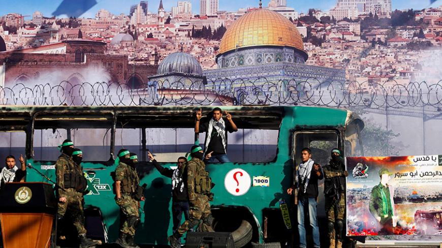 Palestinian Hamas militants march in front of a mock burnt Israeli bus during an anti-Israel rally in Gaza city April 28, 2016.  REUTERS/Suhaib Salem       - RTX2C2ZR