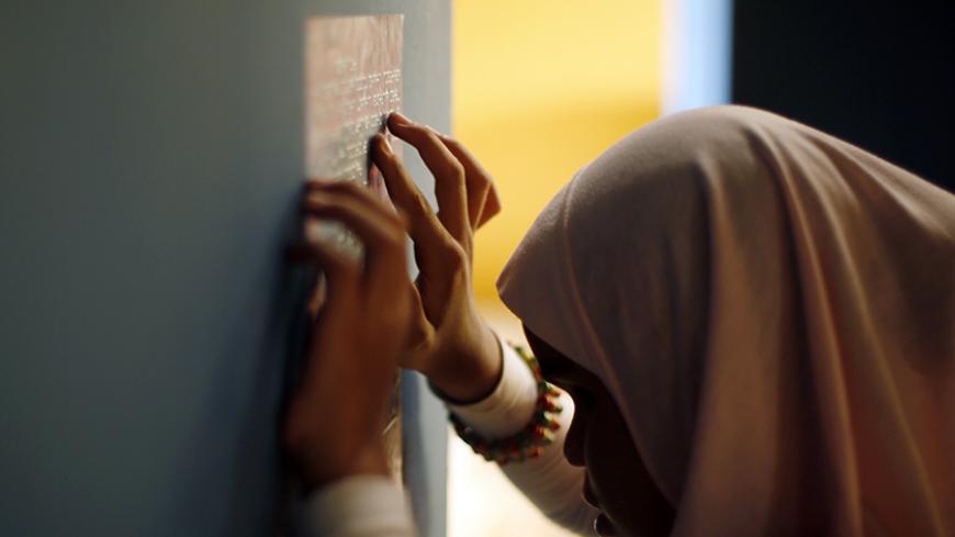 Mena Allah Hussien, a visually impaired girl, reads a Braille description of an installation depicting a pharaonic statue at the Children's Museum as part of the Egyptian Museum in Cairo October 16, 2014. The Egyptian Supreme Council for Antiquities opened its doors to the museum, equipped for the visually impaired, and arranged activities for the children to create an awareness of their heritage. The event was held to mark White Cane Safety Day which fell on October 15. REUTERS/Amr Abdallah Dalsh (EGYPT -