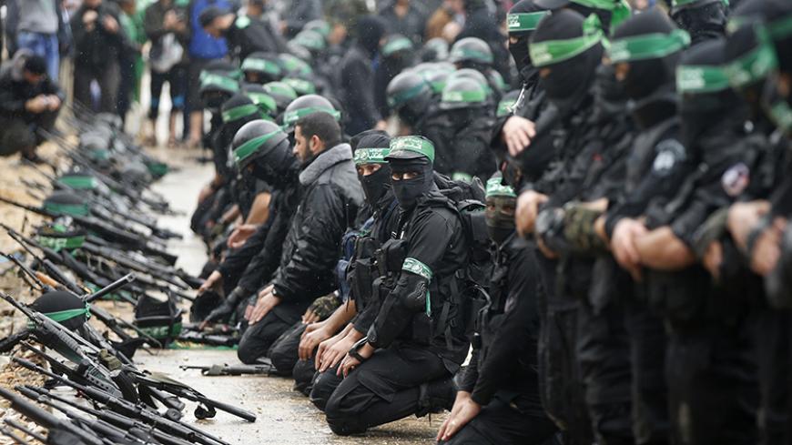 Palestinian members of al-Qassam Brigades, the armed wing of the Hamas movement, pray before a military parade marking the 27th anniversary of Hamas' founding, in Gaza City December 14, 2014. REUTERS/Mohammed Salem (GAZA - Tags: POLITICS MILITARY ANNIVERSARY RELIGION) - RTR4HY0R