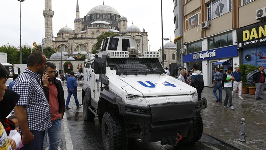 An armoured vehicle drives near a Turkish police bus which was targeted in a bomb attack in a central Istanbul district, Turkey, June 7, 2016.    REUTERS/Osman Orsal - RTSGBSA