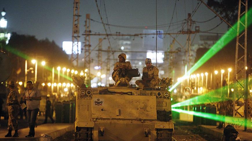 Egyptian Army soldiers sit on an armoured personnel carrier (APC) on a tram track, during a patrol, as supporters of deposed president Mohamed Mursi approach the presidential palace in Cairo, July 19, 2013. Thousands of Mursi's supporters took to the streets of Egyptian cities on Friday to demand the reinstatement of the Islamist leader. However, Egypt's armed forces, which shunted the country's first freely elected president from office less than three weeks ago, looked in no mood to make concessions, putt