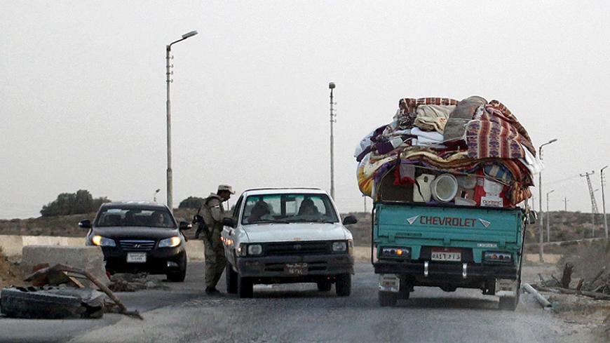 An Egyptian soldier inspects vehicles at a check point in northern Sinai, May 25, 2015. Authorities in the Sinai Peninsula are battling insurgents who support Islamic State, the militant group that has seized parts of Iraq, Syria and Libya. The Sinai conflict, which has has displaced hundreds of Egyptians, is the biggest security challenge for President Abdel Fattah al-Sisi, who has promised to deliver stability after four years of turmoil triggered by the 2011 uprising. Picture taken May 25, 2015. REUTERS/
