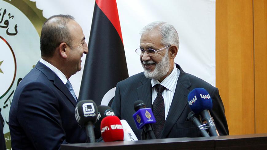 Turkey's Foreign Minister Mevlut Cavusoglu (L) and Mohammed Siyala, foreign minister in Libya's new U.N.-backed national unity government, smile after a joint news conference in Tripoli, Libya, May 30, 2016. REUTERS/Ismail Zitouny - RTX2ETWP