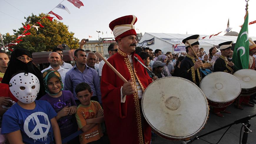 People listen to the Mehter band performing Ottoman army music as they wait for Iftar, the evening meal for breaking fast during Ramadan, on the first day of the Islamic holy month of Ramadan in Istanbul August 1, 2011. REUTERS/Murad Sezer (TURKEY - Tags: RELIGION SOCIETY) - RTR2PJ59