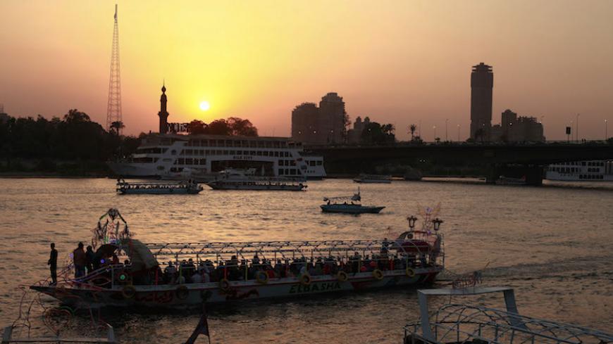People sit in a boat on the river Nile in Cairo June 15, 2012. The Muslim Brotherhood's Mohamed Morsy is tempering forecasts of victory in Egypt's presidential election with a warning that vote rigging typical of the Hosni Mubarak era may hand victory to Ahmed Shafik, the deposed leader's last prime minister. REUTERS/Suhaib Salem (EGYPT - Tags: POLITICS ELECTIONS) - RTR33O5K