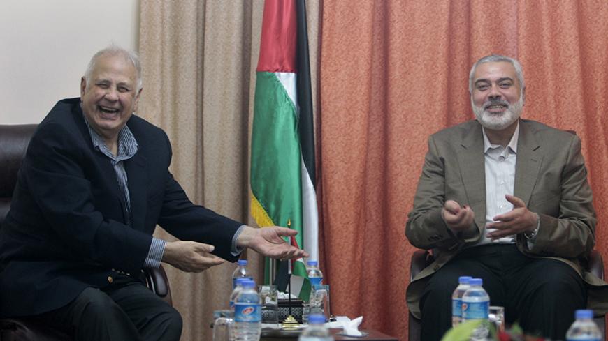 Hamas prime minister Ismail Haniyeh (R) gestures during a meeting with Hanna Nasir (L), chairman of the Palestinian Central Election Commission (CEC), in Gaza City January 30, 2013. REUTERS/Ahmed Zakot (GAZA - Tags: POLITICS) - RTR3D57Q