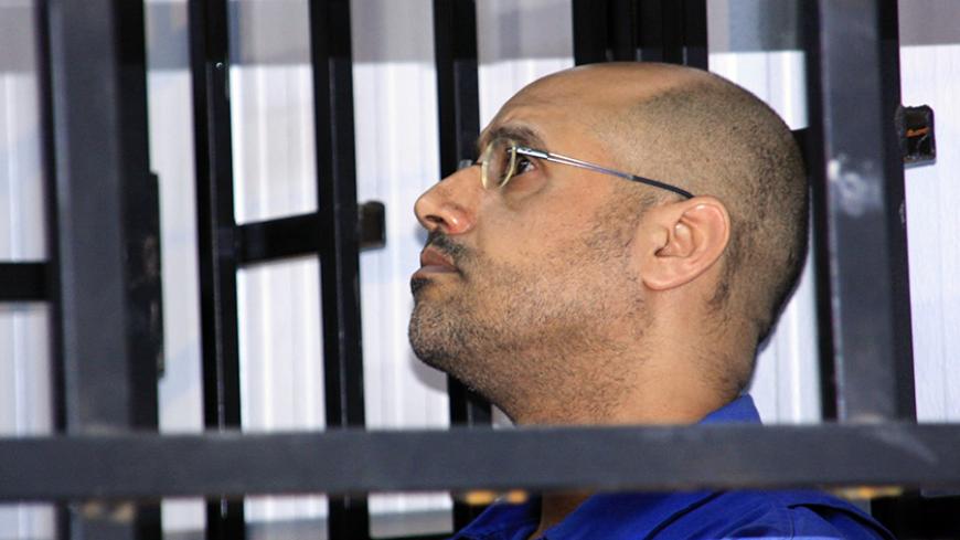 Saif al-Islam Gaddafi, son of late Libyan leader Muammar Gaddafi, attends a hearing behind bars in a courtroom in Zintan May 25, 2014. REUTERS/Stringer (LIBYA - Tags: POLITICS CIVIL UNREST CRIME LAW) - RTR3QSD2
