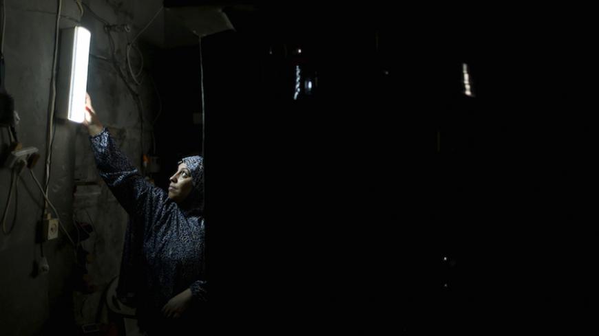 A Palestinian woman hangs a torch inside her house during power cuts at Shatti (beach) refugee camp in Gaza City September 15, 2015. Power has been provided to different areas in the impoverished coastal territory in six-hour shifts as Gaza's lone power plant shut its generators on Saturday due to a fuel shortage, energy officials said. Electricity is also supplied to the Gaza grid through power lines from Israel and Egypt. Gaza's plant provides electricity to two-thirds of its population. REUTERS/Mohammed 